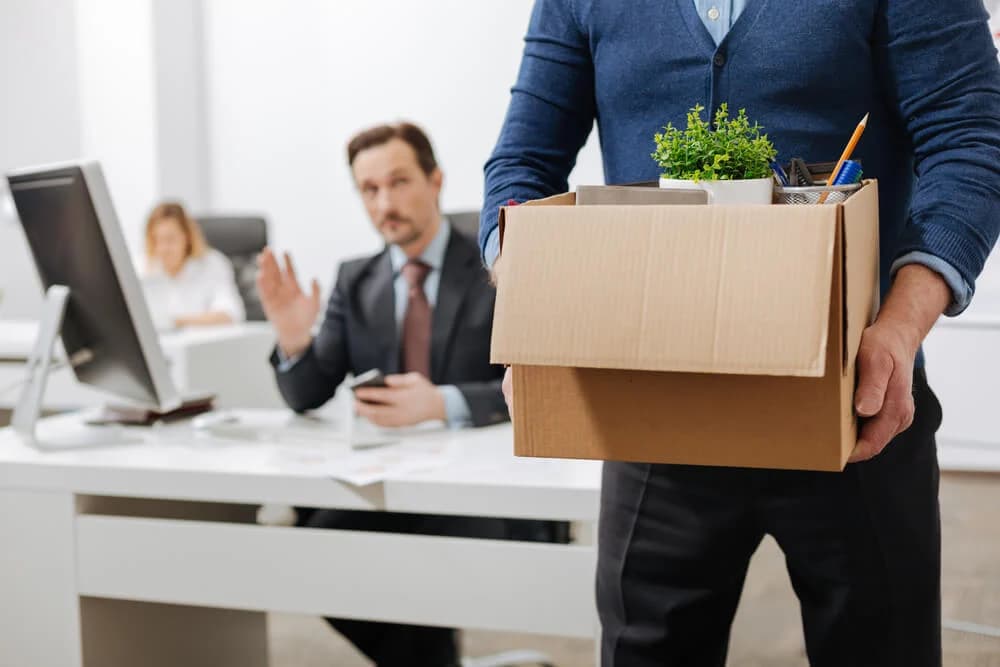 Employee leaving their job carrying a cardboard box