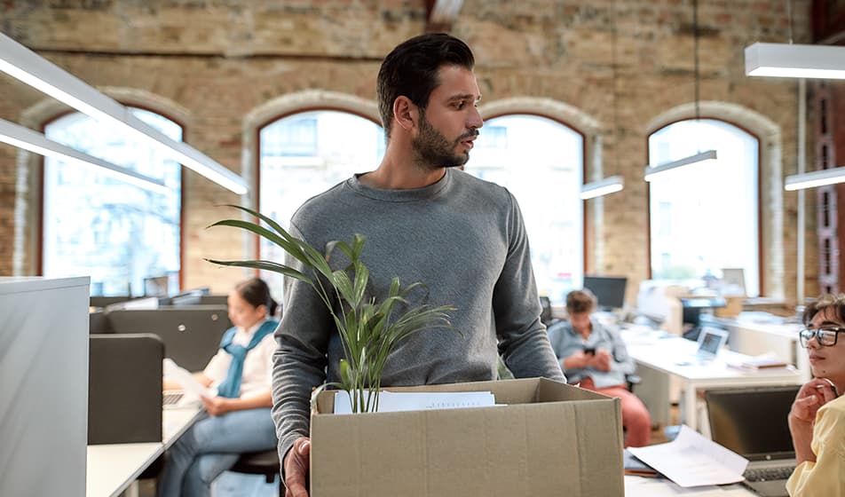 Employee leaving office carrying cardboard box