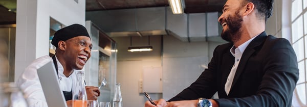 Chef and customer laughing in restaurant